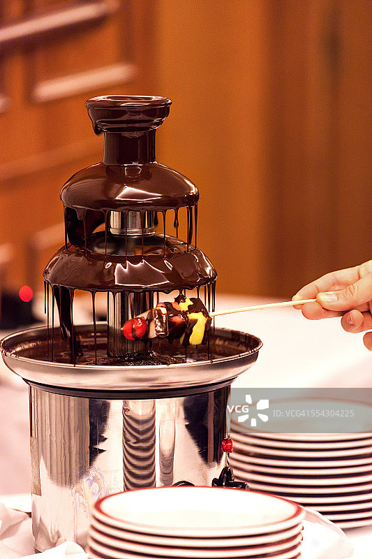 用手将水果蘸入巧克力图片素材
