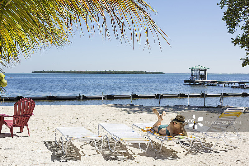 在热带海滩上放松的白人女性图片素材