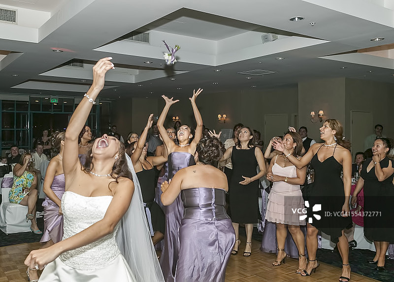 婚礼招待会上新娘向伴娘抛花束图片素材