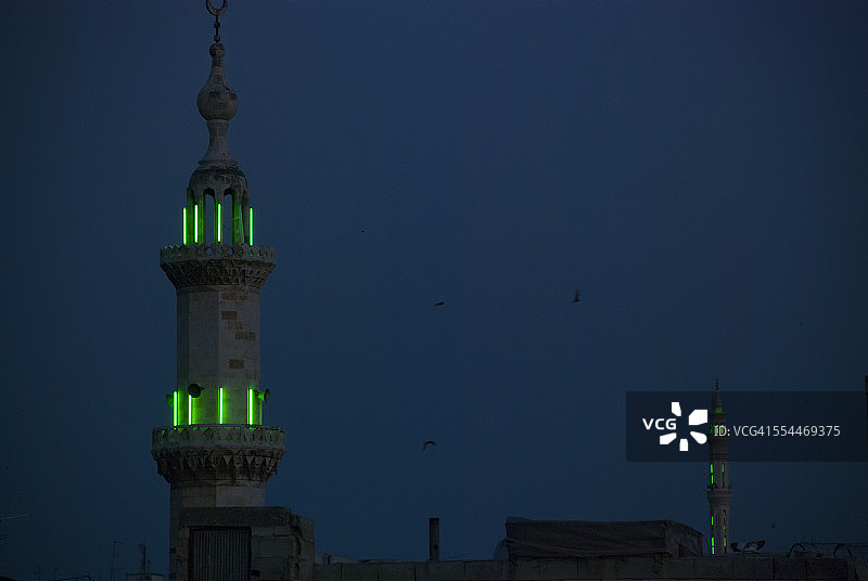 夜晚绿色霓虹灯照亮的尖塔图片素材