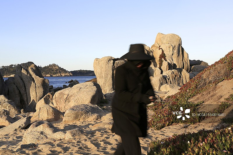 黑色身影与黑边帽子的海边场景图片素材