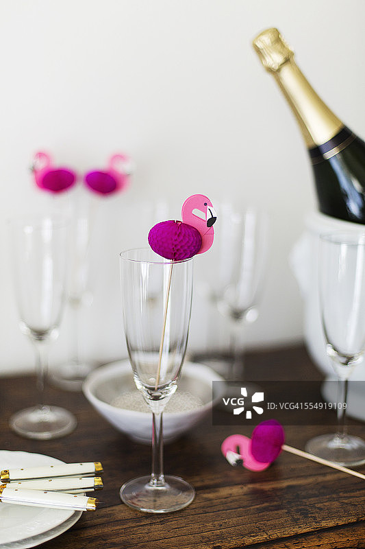 香槟酒瓶、笛形杯和粉红火烈鸟图片素材