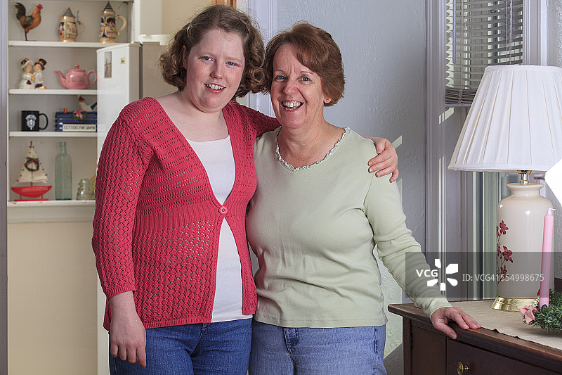 年轻自闭症女子和母亲微笑的肖像图片素材