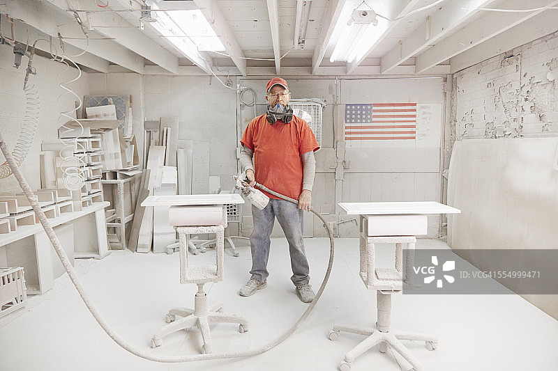 木工在车间喷漆房使用喷枪图片素材