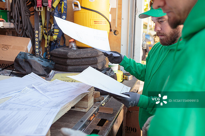 施工人员查看太阳能电池板安装文件图片素材