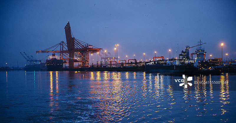 美国华盛顿州塔科马港口夜间货船和龙门起重机的远景图片素材