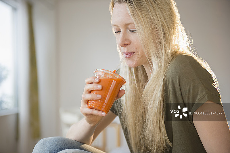 泽西市，喝胡萝卜汁的女人图片素材