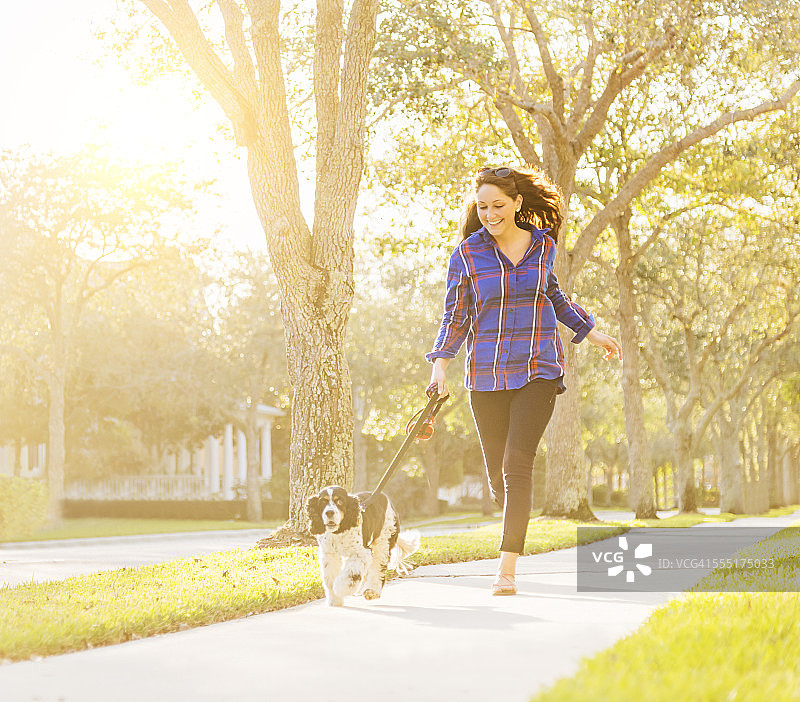 美国佛罗里达州朱庇特，女人与狗跑步图片素材