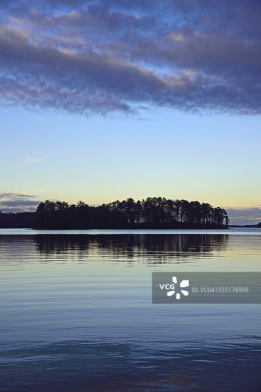 美国佐治亚州拉尼尔湖的树木在黄昏时倒映在湖中图片素材
