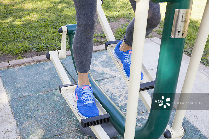 女子在公园使用踏步机锻炼腿部特写图片素材