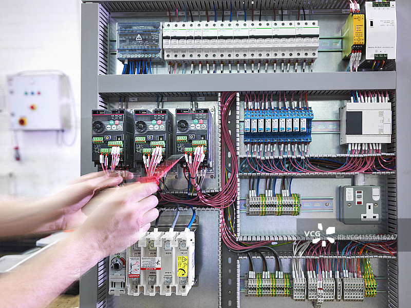 电气工程师在工程工厂测试配电盘的手图片素材