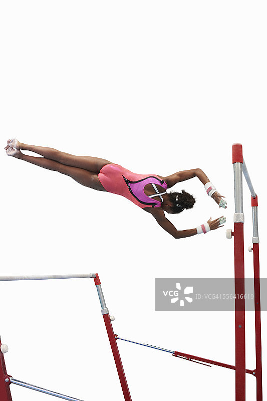 在双杠上表演的年轻体操运动员图片素材