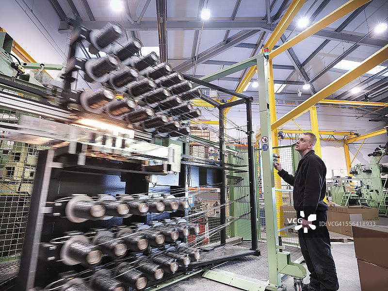 碳纤维工厂操作碳纤维织布机的工人图片素材