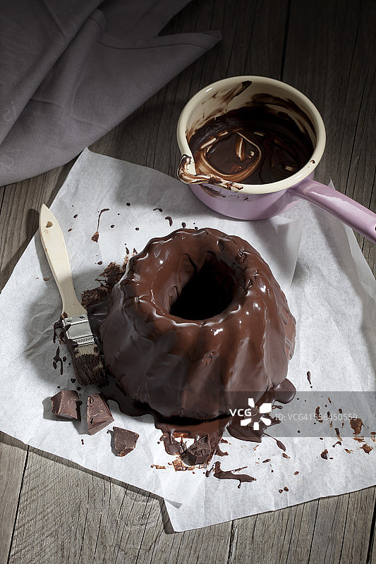 大理石蛋糕、巧克力糖霜、锅和刀（防油纸上）图片素材