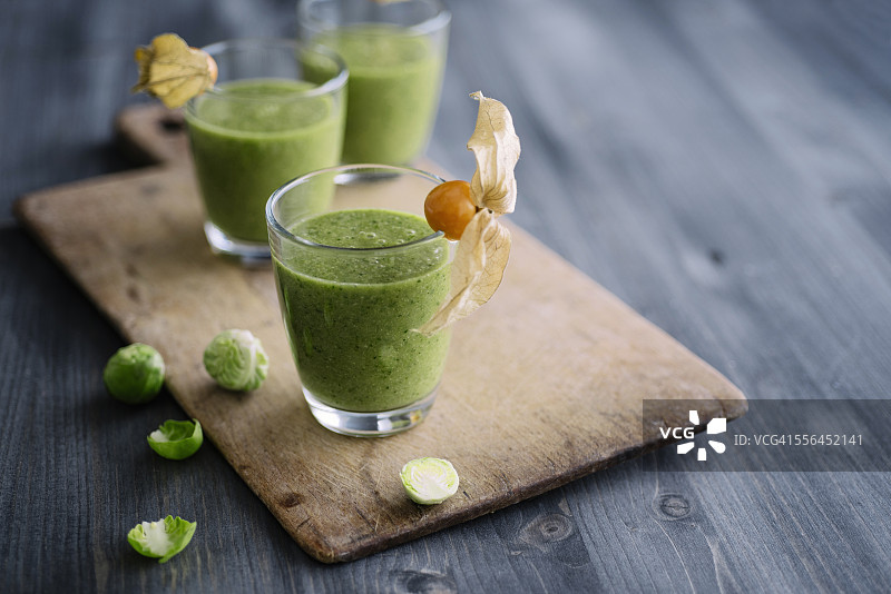 含孢子甘蓝、香蕉和苹果汁的绿色冰沙，饰以酸浆果图片素材