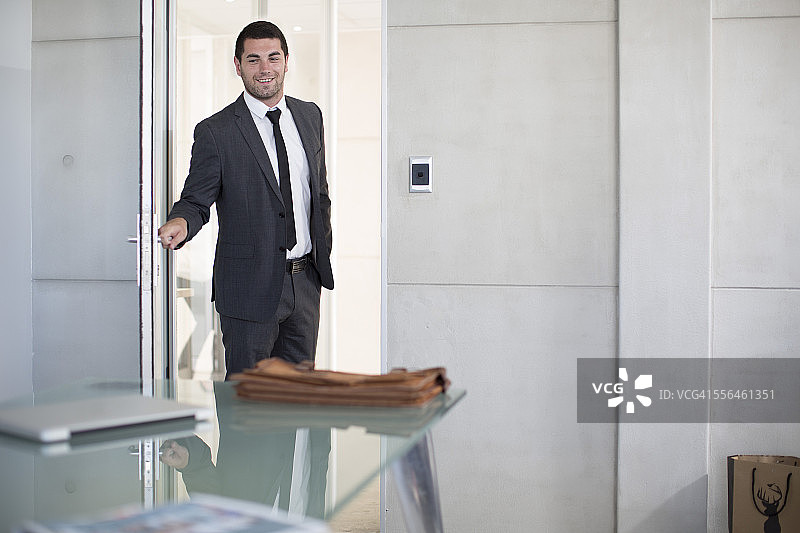 西装革履的商人打开会议室的门图片素材