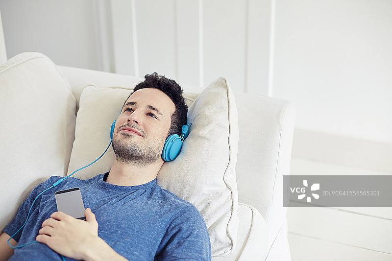 男人在沙发上放松听音乐图片素材