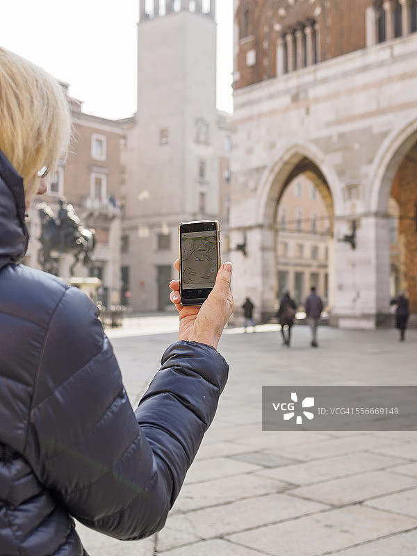 意大利皮亚琴察卡瓦利广场使用智能手机的女游客图片素材