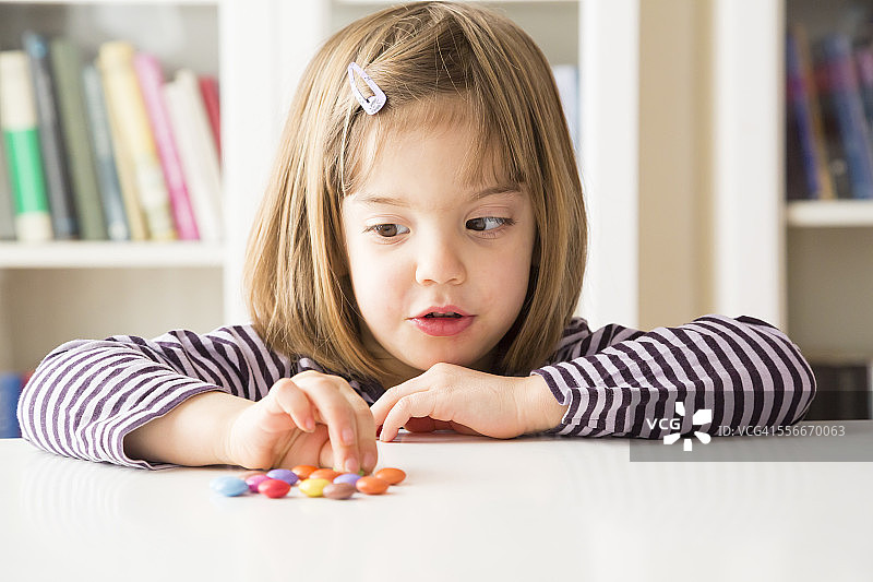 小女孩玩巧克力豆图片素材