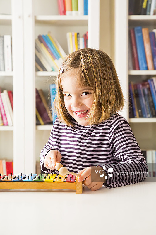 快乐小女孩演奏木琴的肖像图片素材