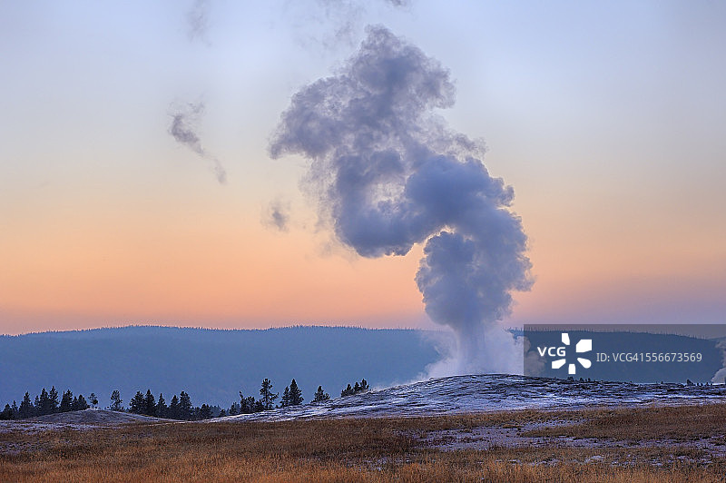 美国怀俄明州黄石国家公园日落时喷发的老忠实间歇泉图片素材