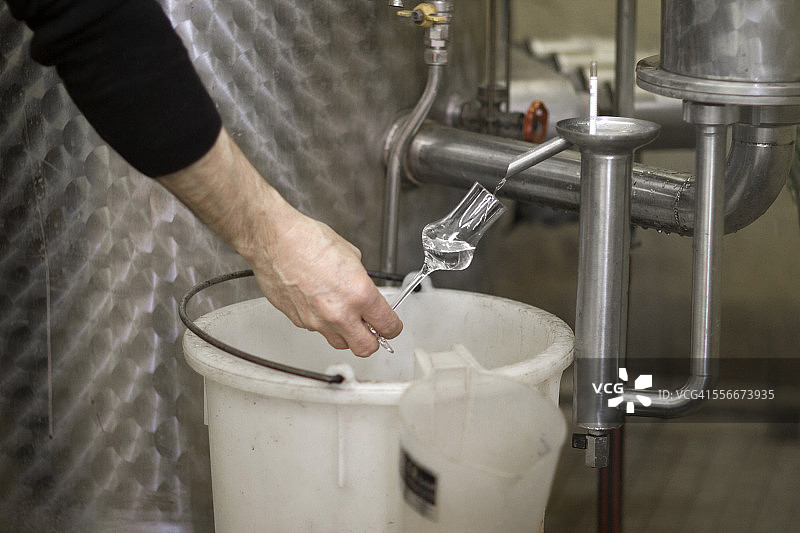 在酿酒厂测试烧酒的酿酒师图片素材