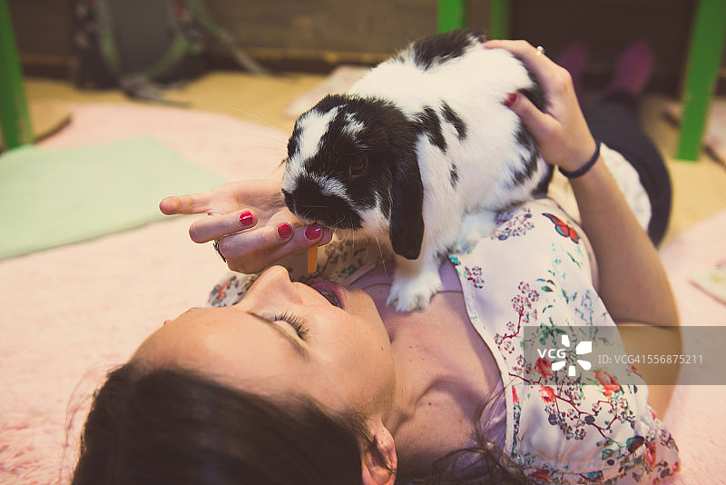 女人在东京的咖啡馆里喂兔子图片素材