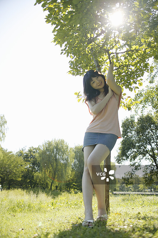 年轻女人站在树下图片素材