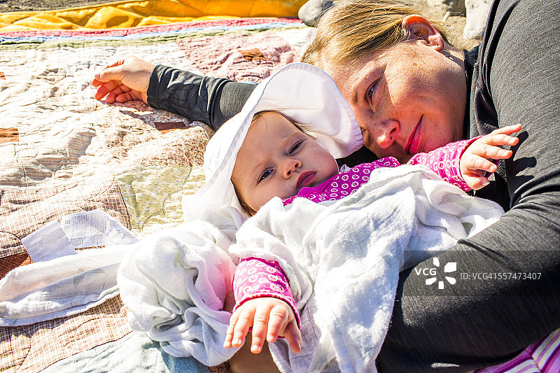 白人母亲和女婴躺在毯子上特写图片素材
