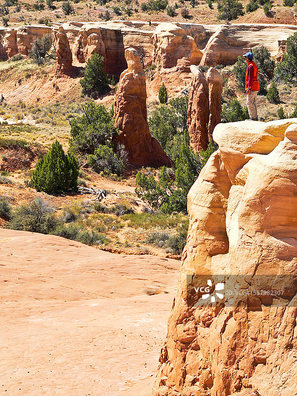 在犹他州埃斯卡兰特魔鬼花园的石柱上徒步旅行者图片素材