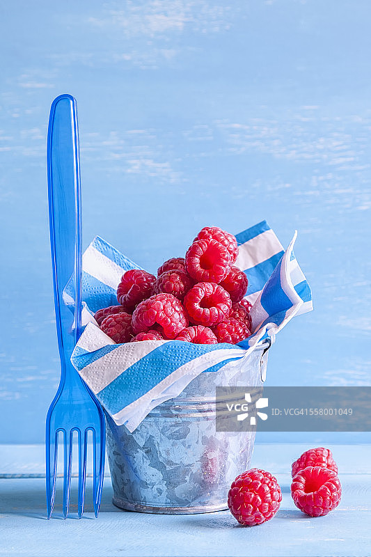 装满覆盆子的镀锌金属桶图片素材