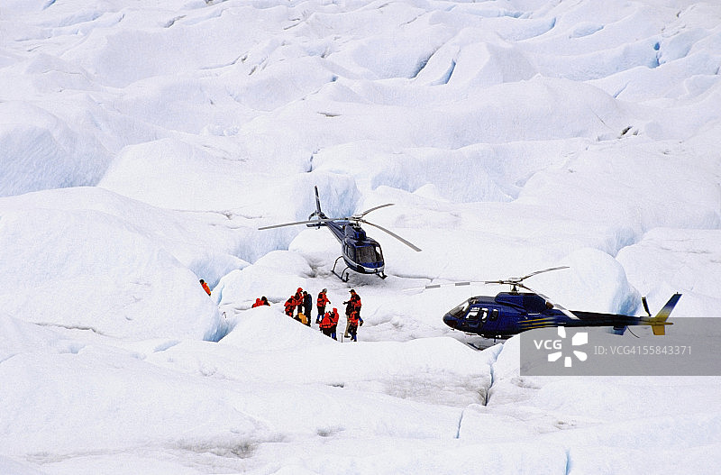 美国阿拉斯加朱诺门登霍尔冰川上的游客和直升机图片素材