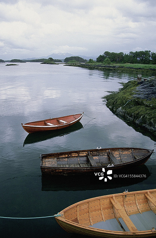 停泊在海滩上的三艘渔船，位于挪威莫尔德的耶尔托亚岛图片素材