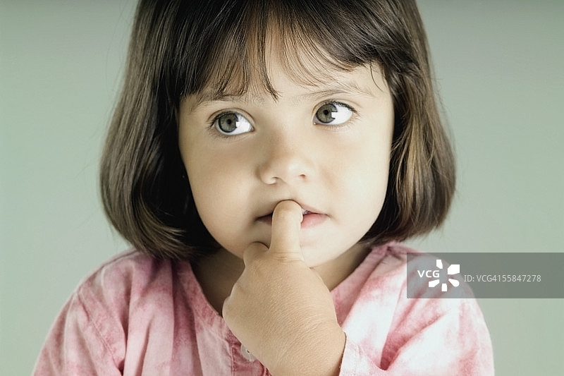 手指放在嘴里的女孩特写图片素材