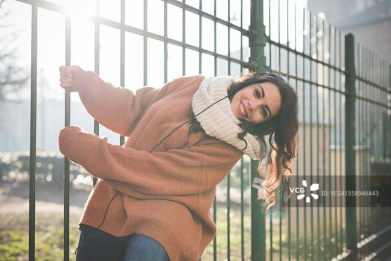 年轻女人荡公园栏杆图片素材
