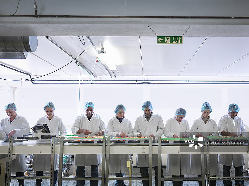 巧克力工厂生产线上包装巧克力的工人图片素材