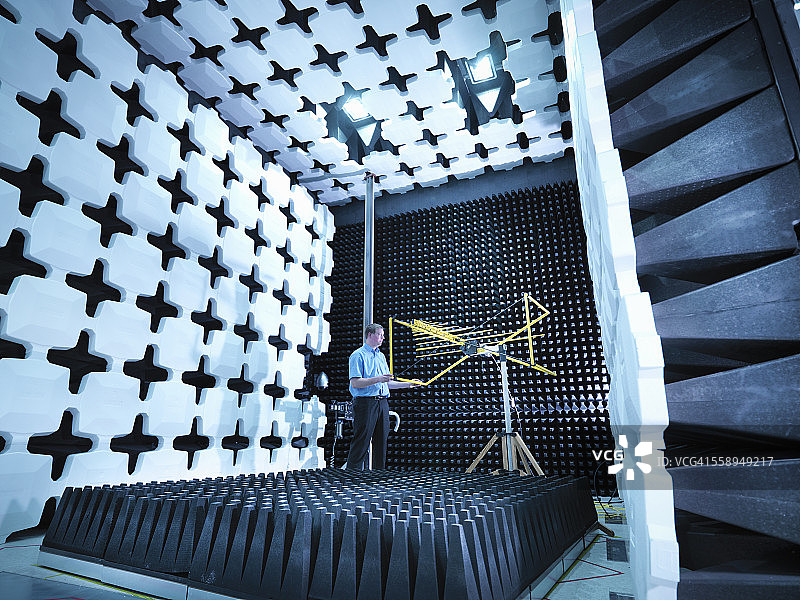 工程师检查电磁兼容性（EMC）的 bilog 天线装置，用于在消声室中辐射能量吸收器的辐射图片素材
