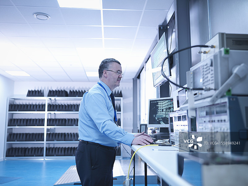 电磁兼容工程师在消声室中使用高性能电源和网络分析仪对电气设备进行辐射发射扫描图片素材