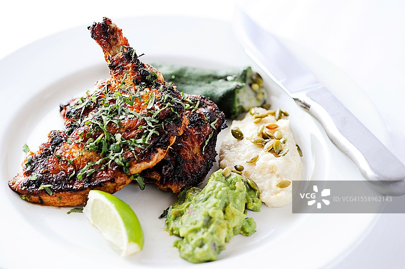 砖块鸡肉：烤鸡配酿辣椒、鳄梨酱和土豆图片素材