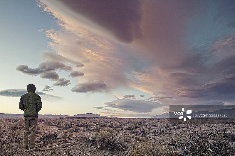 站在戏剧性天空下的男人图片素材