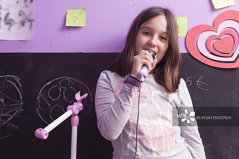 女孩房间里手持麦克风唱歌图片素材