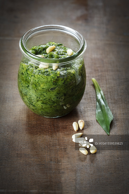 木头上的自制野蒜香蒜酱、叶子和松子图片素材