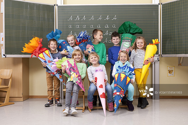 教室里一群戴着学校锥形帽的快乐小学生图片素材