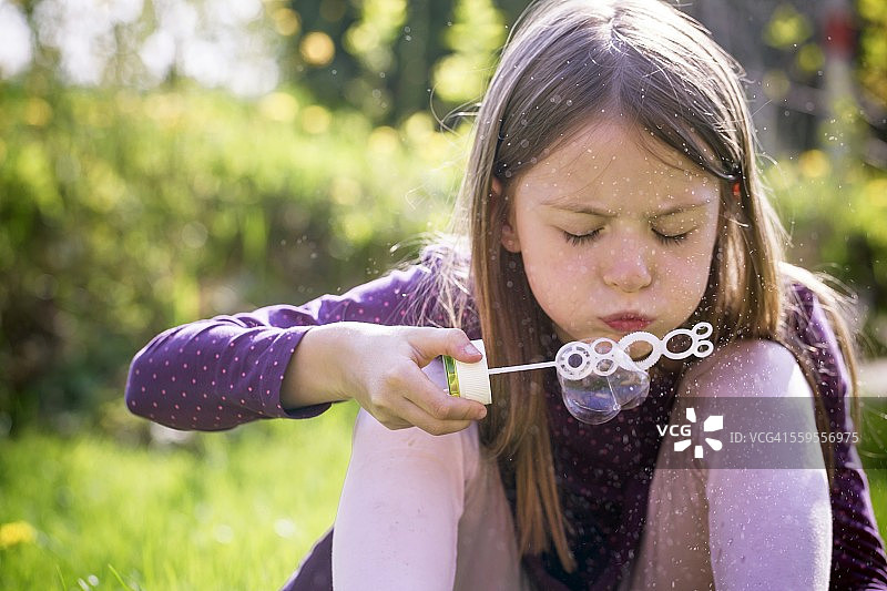 在花园里吹肥皂泡的女孩图片素材
