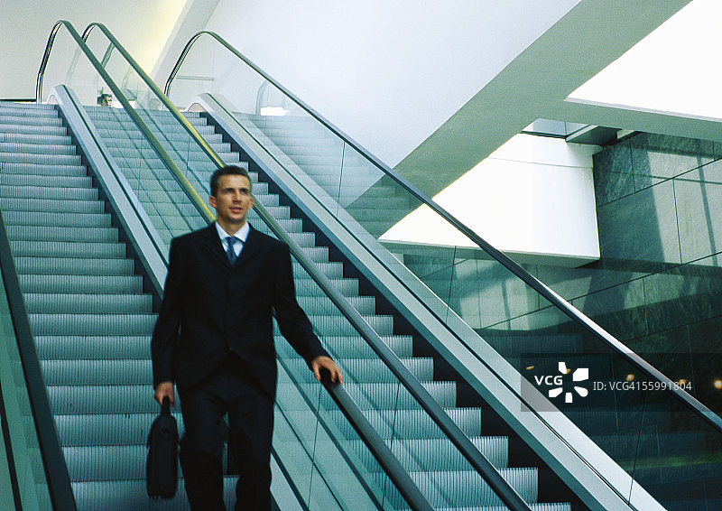 乘坐下行自动扶梯的商人图片素材