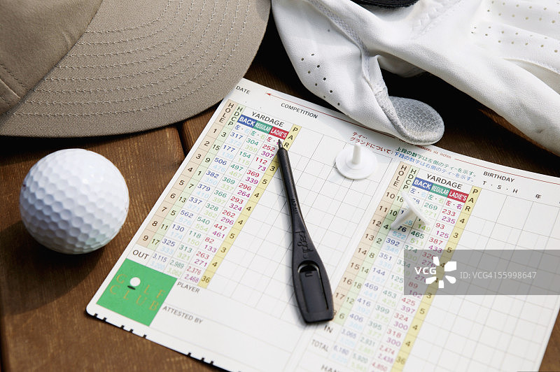 长凳上的记分卡、高尔夫球、笔、帽子和高尔夫手套图片素材