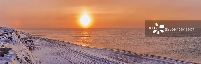 夕阳穿过风吹的雪，在美国阿拉斯加州巴罗郊外的博福特海沿岸形成幻日图片素材