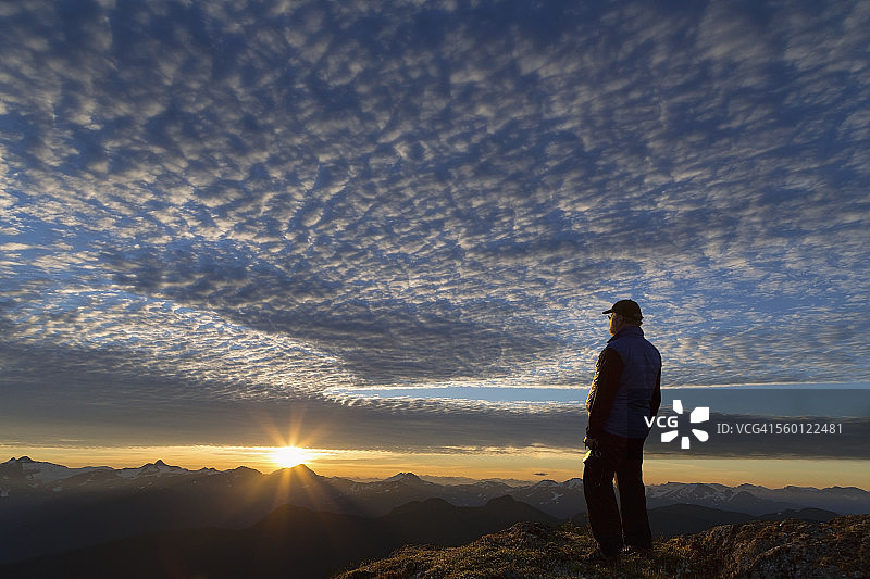 阿拉斯加朱诺道格拉斯岛汤加斯国家森林公园高山日出时海岸山脉与徒步者图片素材