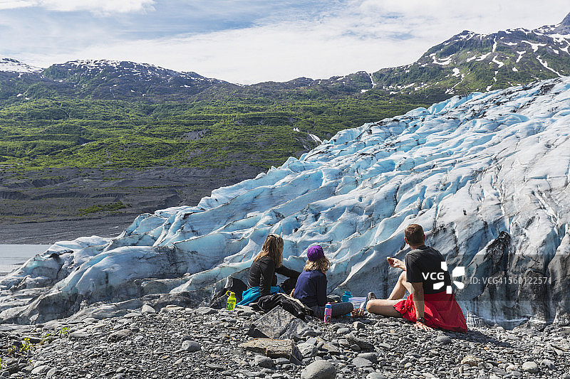 一对夫妇和女儿在眺望冰川时吃零食，威廉王子湾休普湾海洋公园图片素材