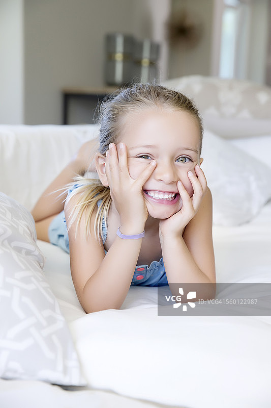 躺在沙发上，笑着的小女孩图片素材